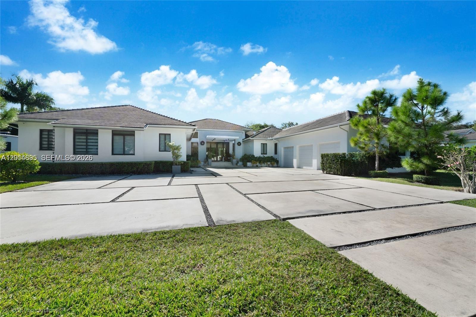 7830 Southwest 117th Street Pinecrest, FL 33156 - Photo 2 of 24 a house with green field in front of it