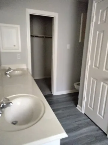 a view of an empty room with wooden floor and a cabinet