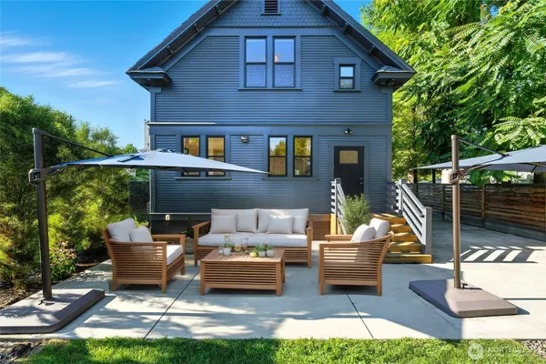 a view of a patio with couches table and chairs and potted plants