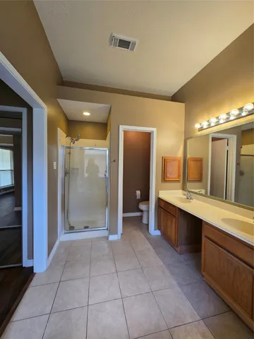 a large bathroom with a large mirror vanity and shower