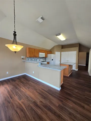 a view of a kitchen with furniture and wooden floor