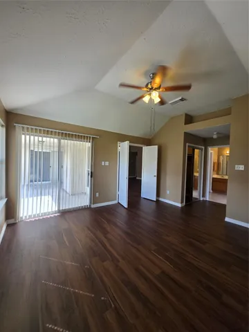 a view of an empty room with window and wooden floor