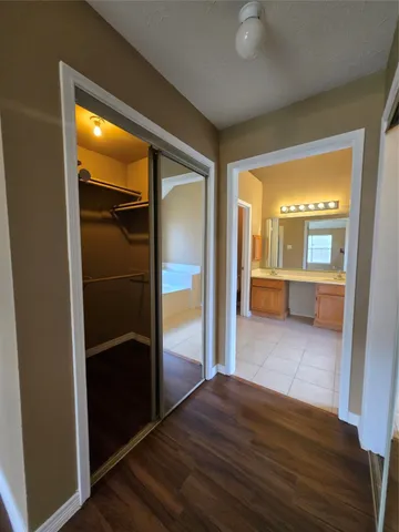 wooden floor in an empty room with a bathroom