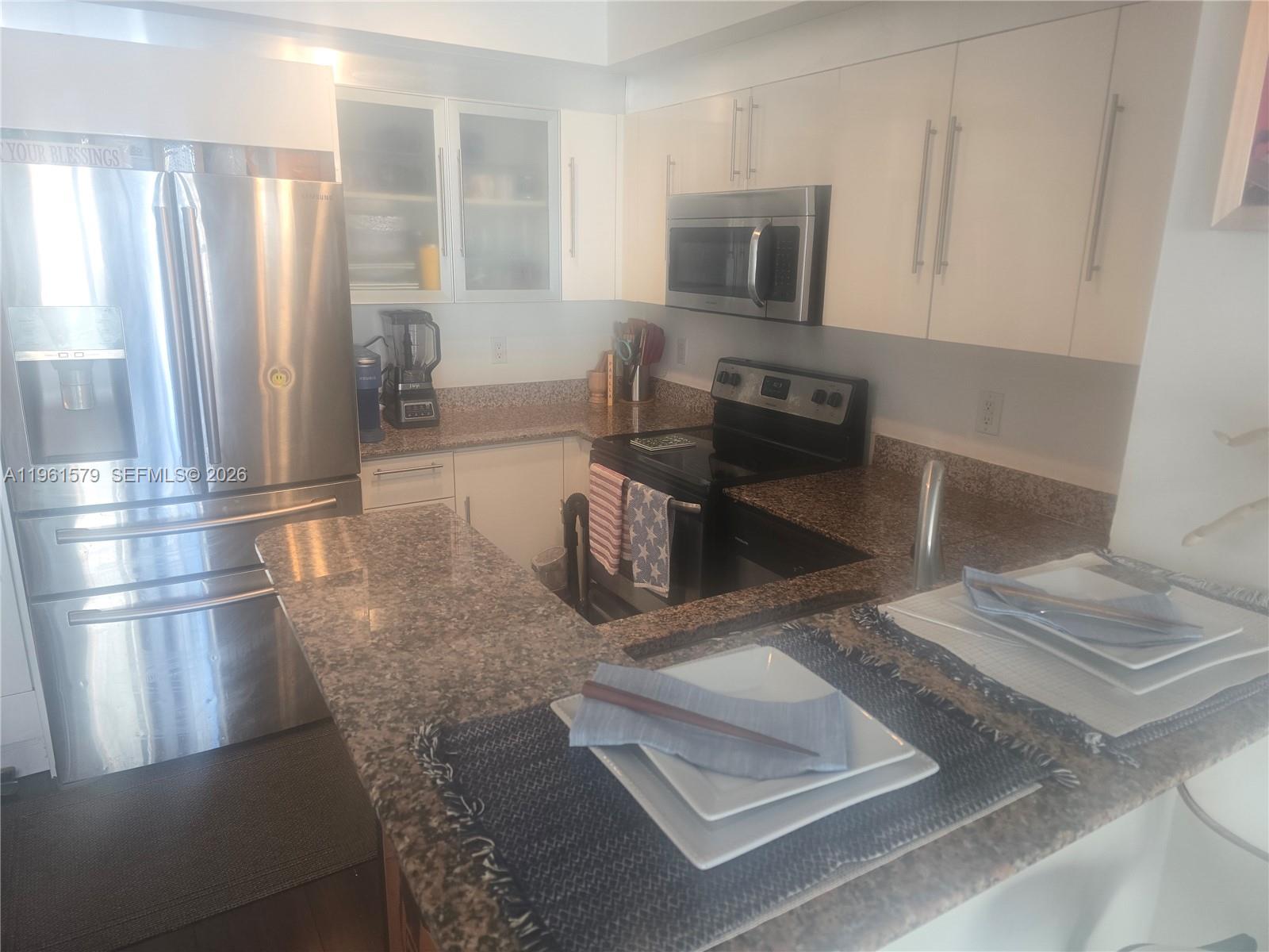 335 South Biscayne Boulevard, Unit 3400 Miami, FL 33131 - Photo 11 of 52 a kitchen with stainless steel appliances granite countertop a refrigerator a stove and a sink