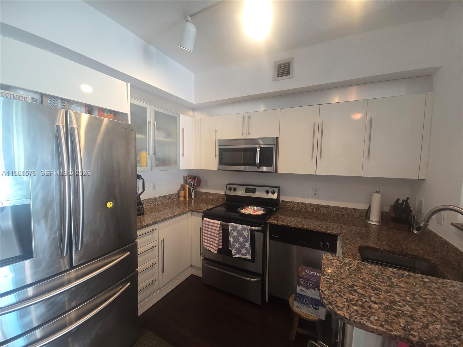 335 South Biscayne Boulevard, Unit 3400 Miami, FL 33131 - Photo 12 of 52 a kitchen with stainless steel appliances granite countertop a refrigerator stove and sink