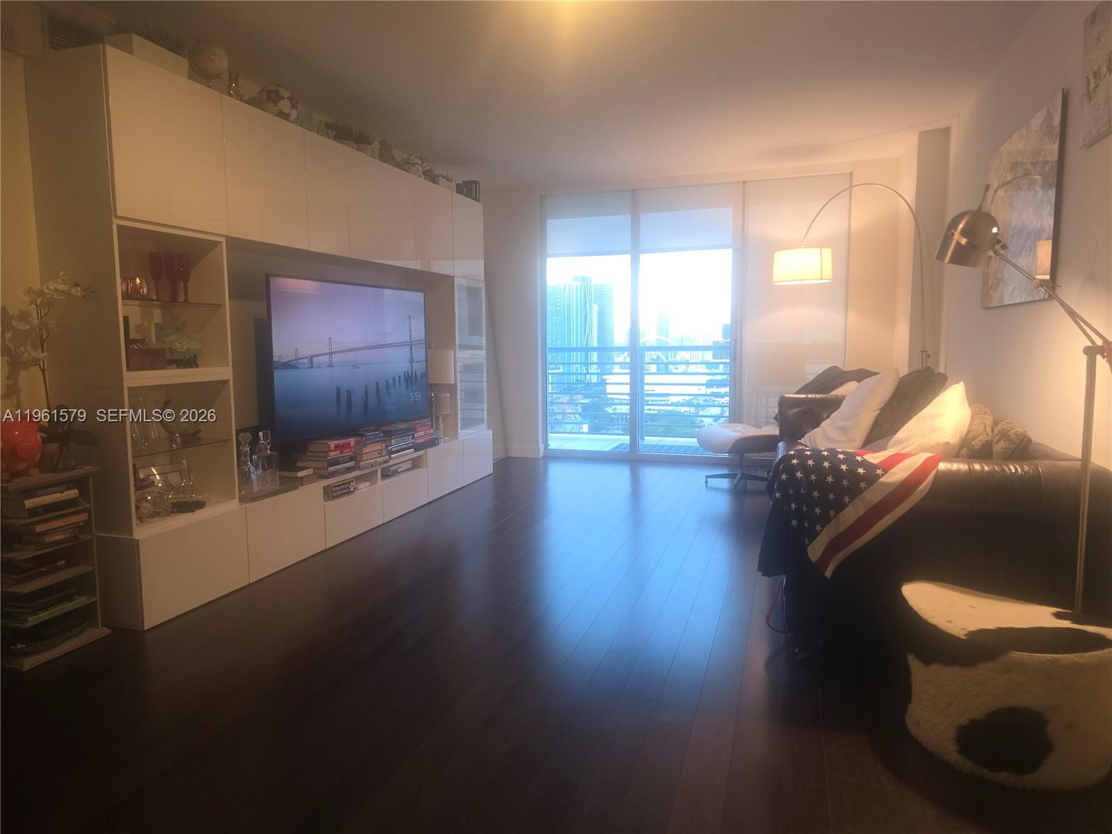 335 South Biscayne Boulevard, Unit 3400 Miami, FL 33131 - Photo 2 of 52 a living room with furniture and a flat screen tv