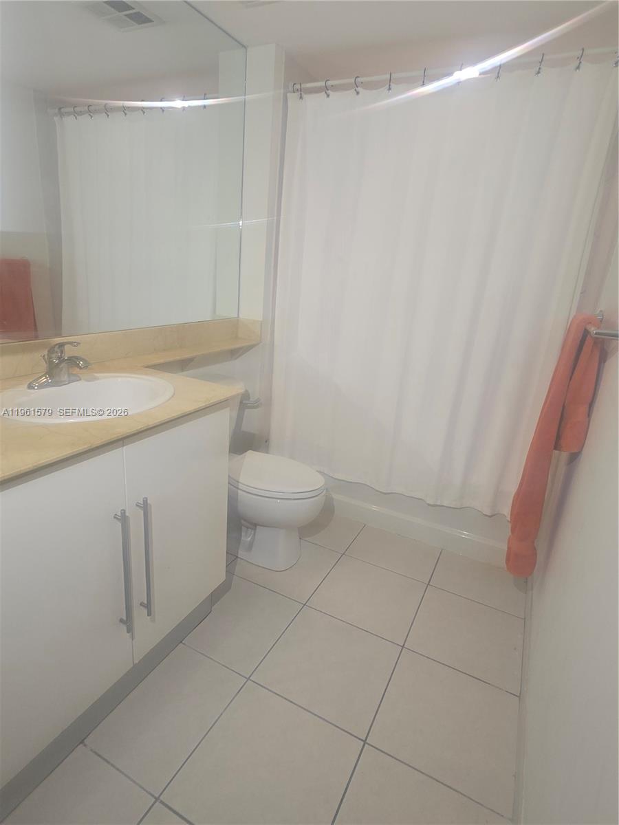 335 South Biscayne Boulevard, Unit 3400 Miami, FL 33131 - Photo 32 of 52 a bathroom with a granite countertop sink a toilet and a mirror