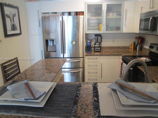 335 South Biscayne Boulevard, Unit 3400 Miami, FL 33131 - Photo 41 of 52 a kitchen with stainless steel appliances granite countertop a refrigerator and a stove top oven