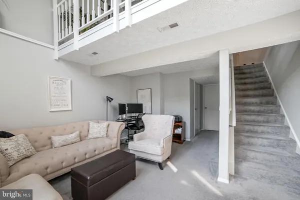 a living room with furniture and a ceiling fan