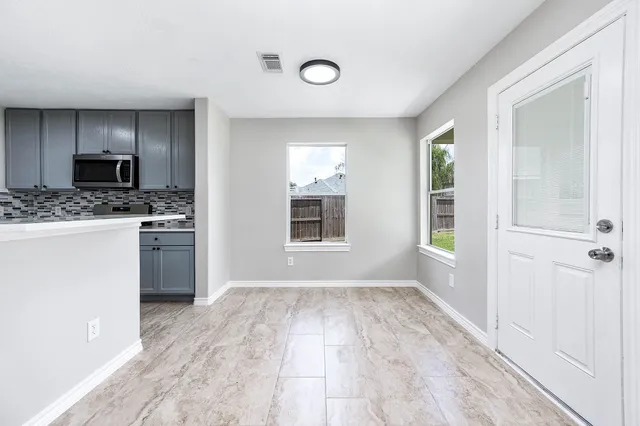 a kitchen with granite countertop a stove a sink and a refrigerator