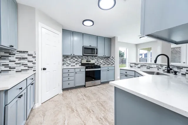 a kitchen with white cabinets and stainless steel appliances