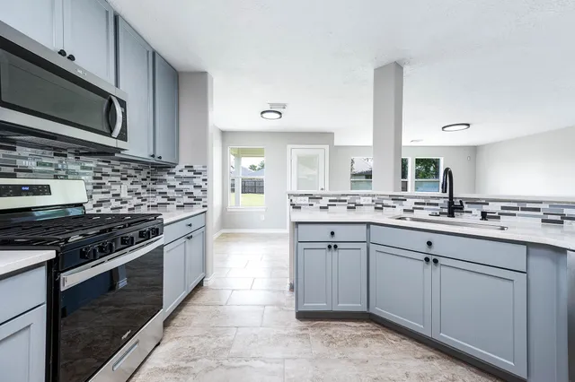 a kitchen with stainless steel appliances granite countertop a sink and stove top oven