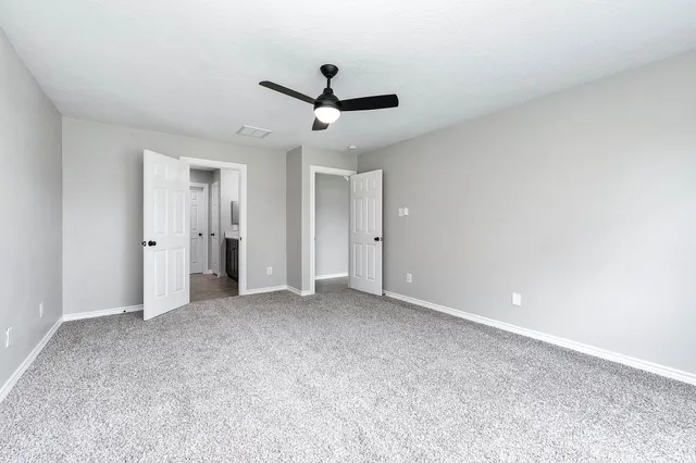 a view of an empty room with a ceiling fan