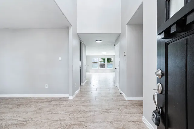 a view of a hallway with wooden floor and a living room