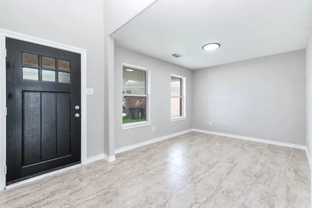 an empty room with windows and closet