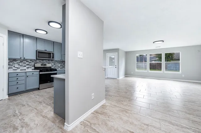 a kitchen with stainless steel appliances granite countertop a stove and a refrigerator