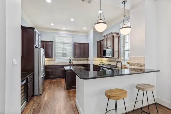 a kitchen with stainless steel appliances granite countertop a sink a stove and a refrigerator