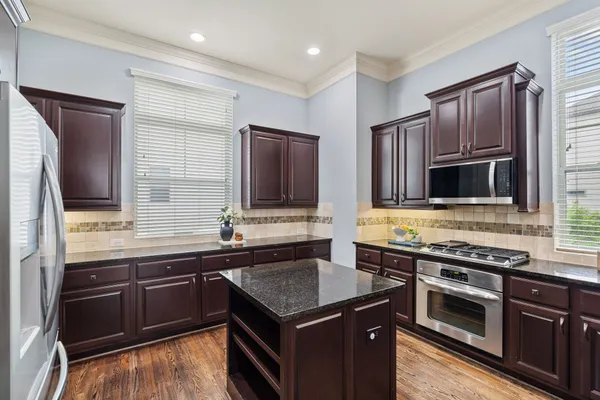 a kitchen with a stove sink and cabinets