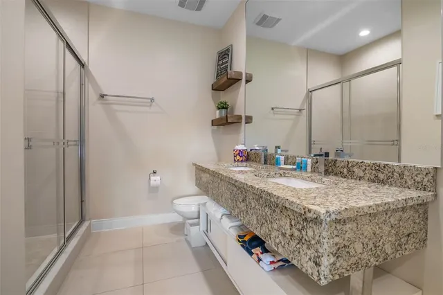a bathroom with a granite countertop sink a toilet and shower
