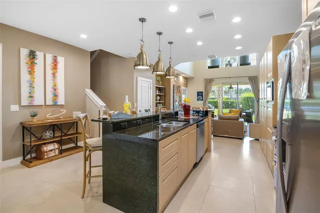 a kitchen with stainless steel appliances granite countertop a sink a stove and a refrigerator