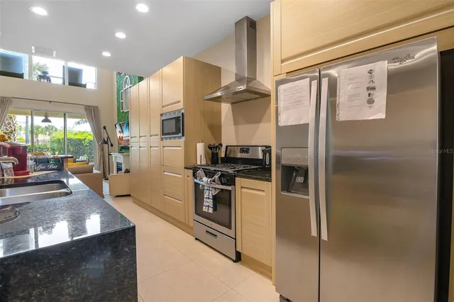 a kitchen with stainless steel appliances granite countertop a refrigerator and a stove