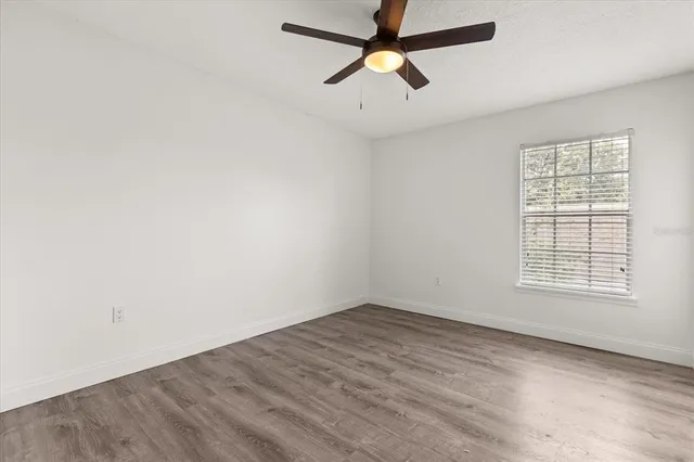an empty room with a window and a fan