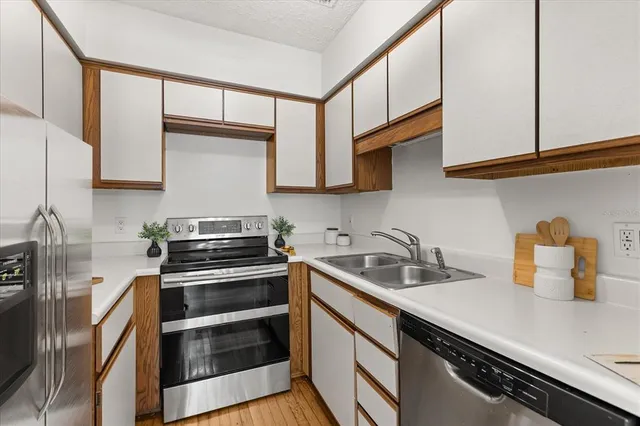 a kitchen with stainless steel appliances a sink dishwasher stove and cabinets