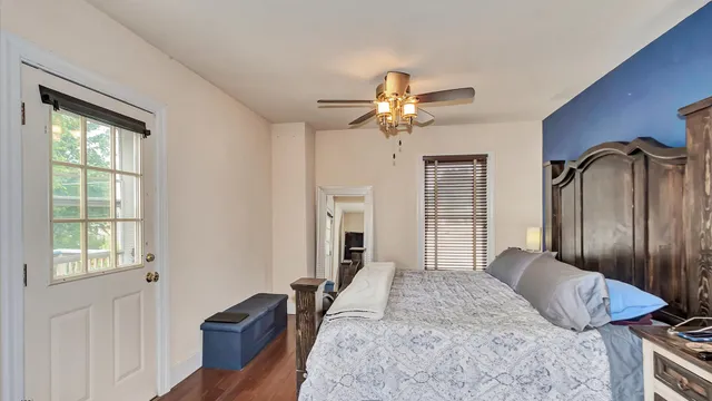 a bedroom with a bed ceiling fan and a window