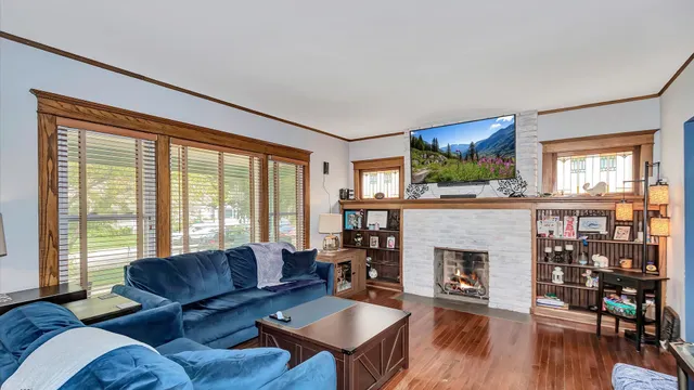 a living room with furniture a fireplace and a floor to ceiling window