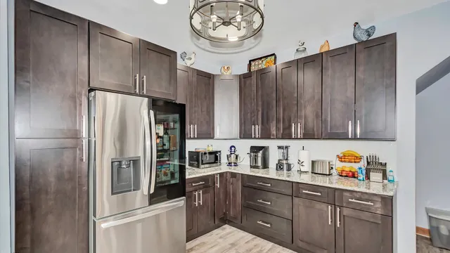 a kitchen with stainless steel appliances granite countertop a refrigerator a stove and a sink with dishwasher