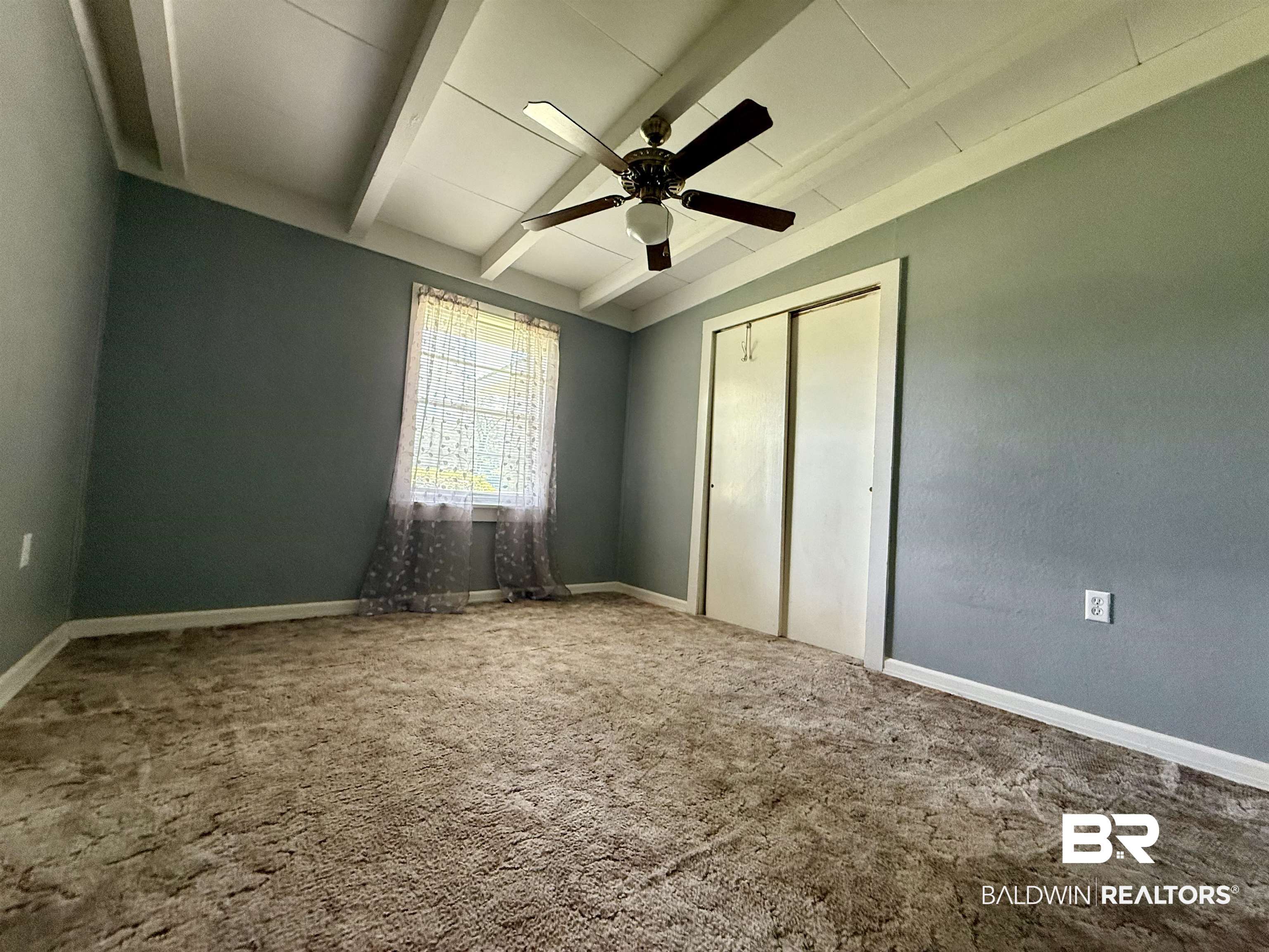 103 Kimberly Street Brewton, AL 36426 - Photo 11 of 18 Unfurnished bedroom with beamed ceiling, carpet flooring, a closet, and ceiling fan