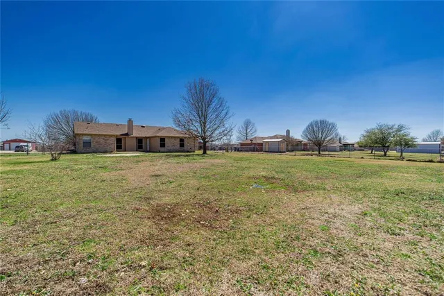 a view of a field of grass and trees