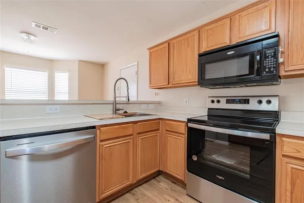 a kitchen with stainless steel appliances a stove microwave and sink