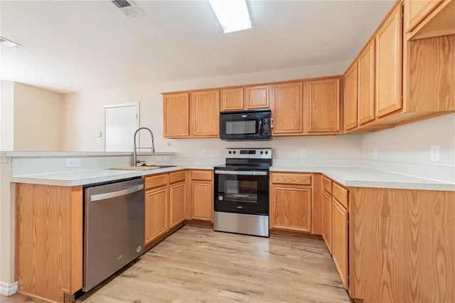 a kitchen with stainless steel appliances granite countertop a sink and cabinets
