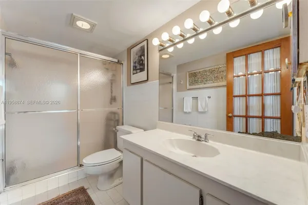 a bathroom with a toilet a sink and a large mirror