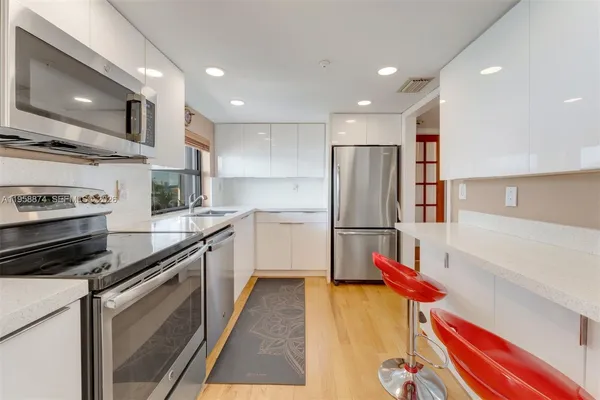 a kitchen with stainless steel appliances kitchen island granite countertop a refrigerator and a stove top oven