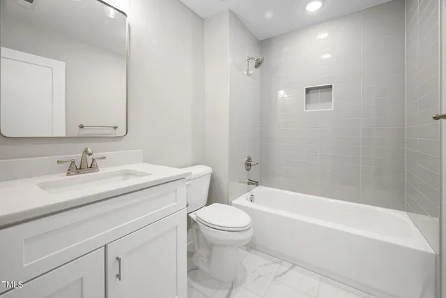 a bathroom with a granite countertop sink a toilet and a bathtub