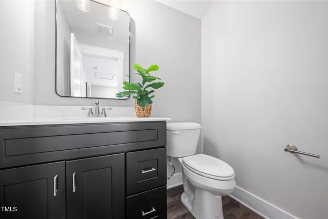 a bathroom with a toilet a sink and mirror