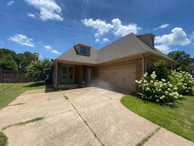 a front view of a house with a yard and a garden