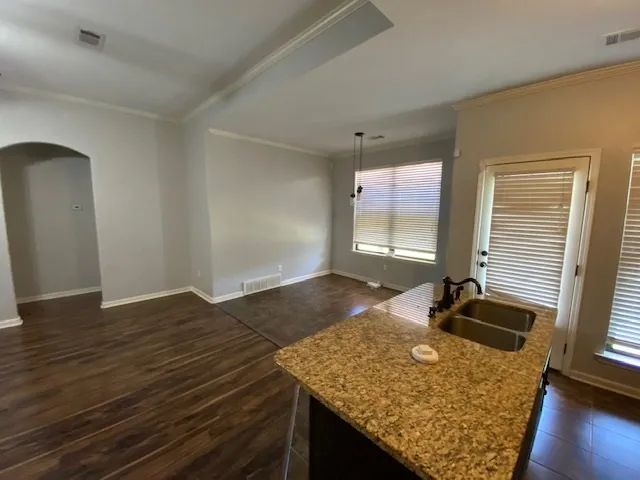 a kitchen with granite countertop sink and cabinets