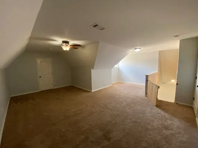 a view of a big room with lamp and chandelier fan