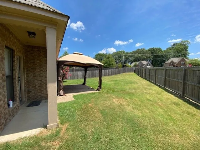 a view of a backyard with a patio and fire pit