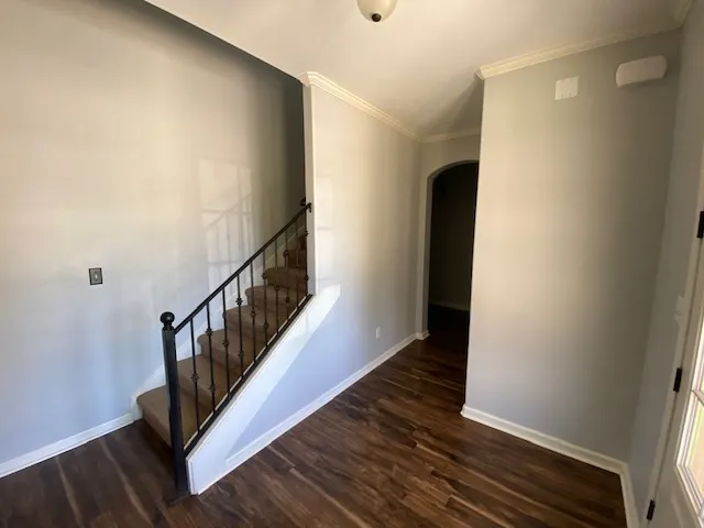 a view of a hallway with wooden floor and stairs