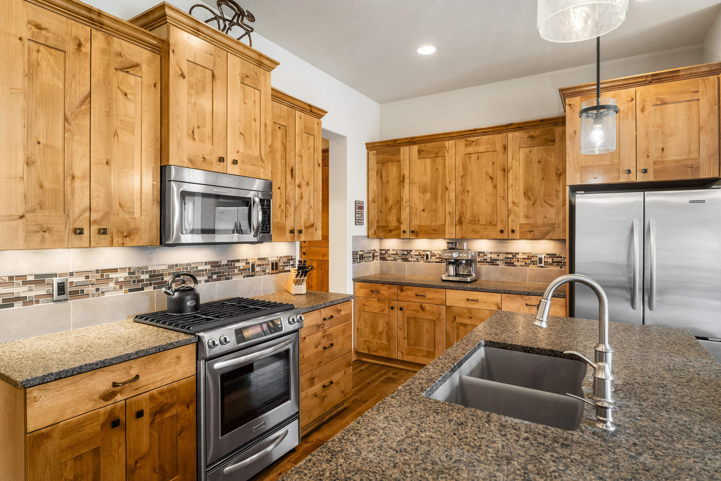 18667 Coffee Court Bend, OR 97702 - Photo 15 of 30 a kitchen with stainless steel appliances granite countertop a stove a sink and a microwave
