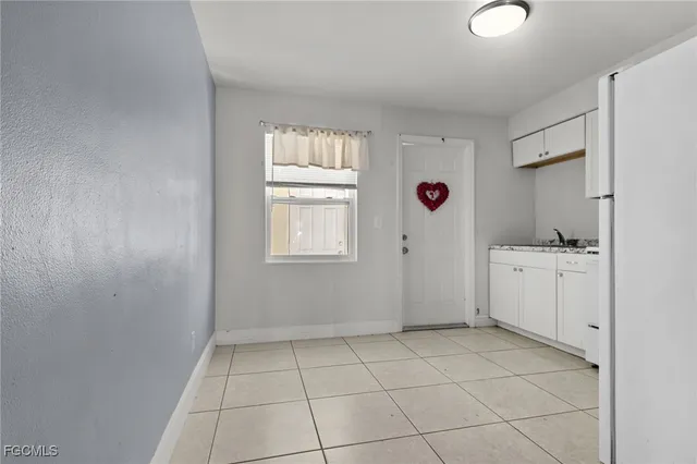 a view of kitchen with cabinets and window