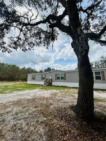 a view of house with outdoor space and trees