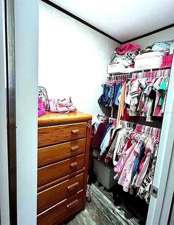 a view of walk in closet with clothes
