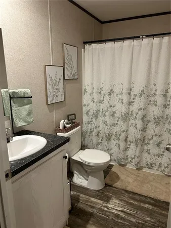 a bathroom with a granite countertop toilet sink and a mirror