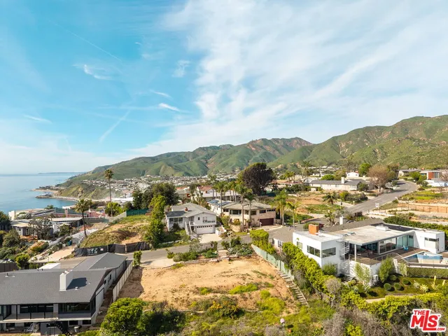 an aerial view of residential houses with city view