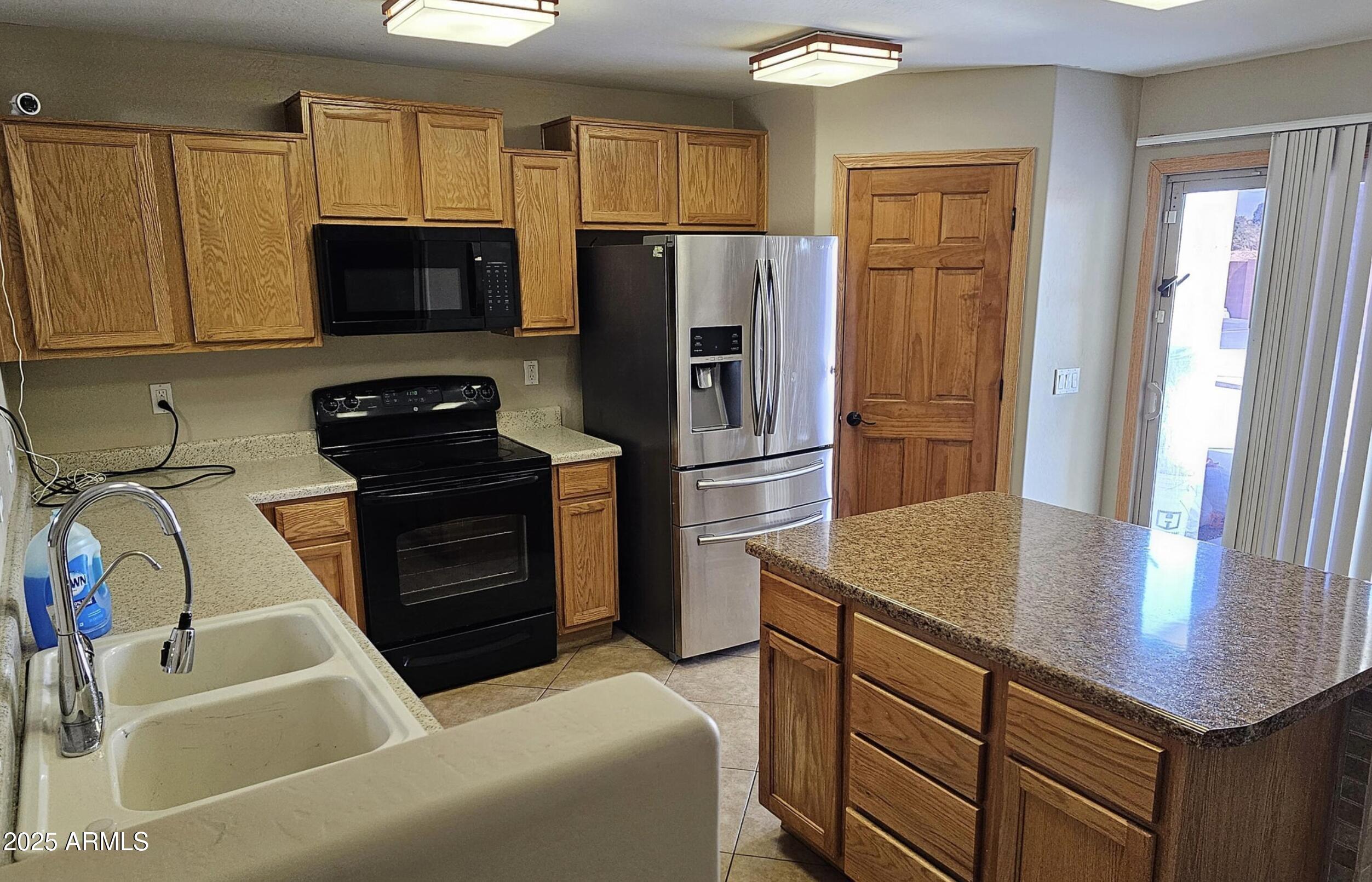 139 North Carter Ranch Road Coolidge, AZ 85128 - Photo 23 of 28 a kitchen with stainless steel appliances granite countertop a refrigerator a stove and a sink with wooden floor
